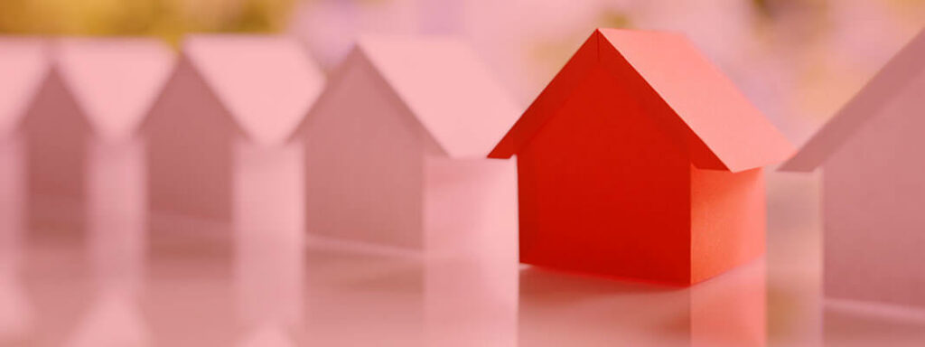 Chamada para o programa Minha Casa Minha Vida sendo representada por casas em miniatura alinhadas